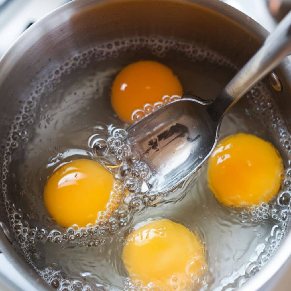 Poaching eggs in simmering water