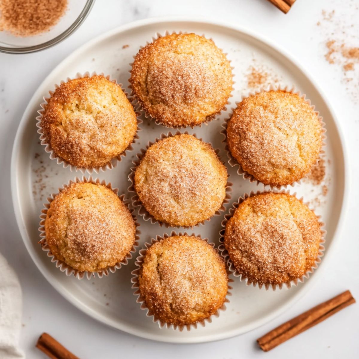 Freshly baked cinnamon muffins recipe on a wire rack with cinnamon sticks