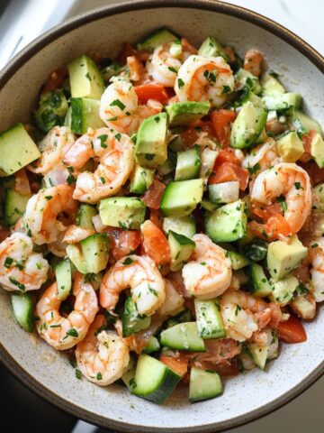 Fresh shrimp salad with creamy dressing on a rustic kitchen counter.