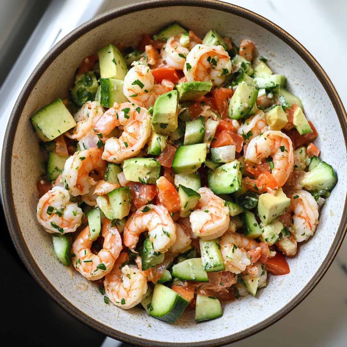 Fresh shrimp salad recipe with creamy dressing on a rustic kitchen counter.