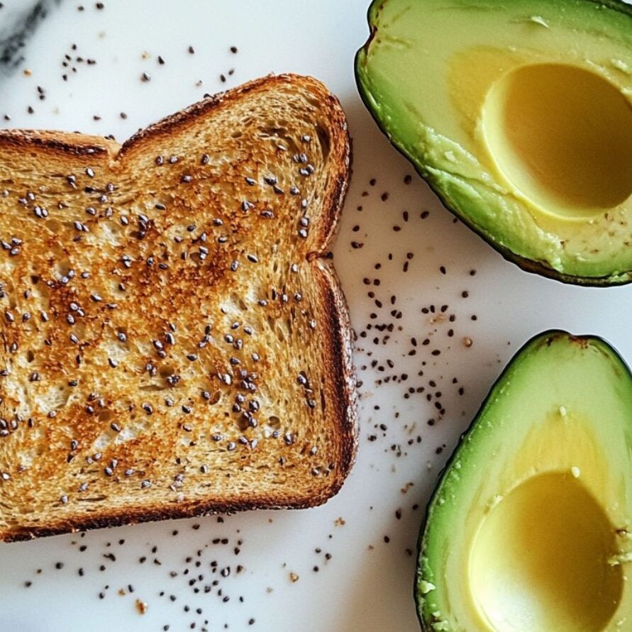 Assembling homemade avocado toast with mashed avocado spread on toasted bread.