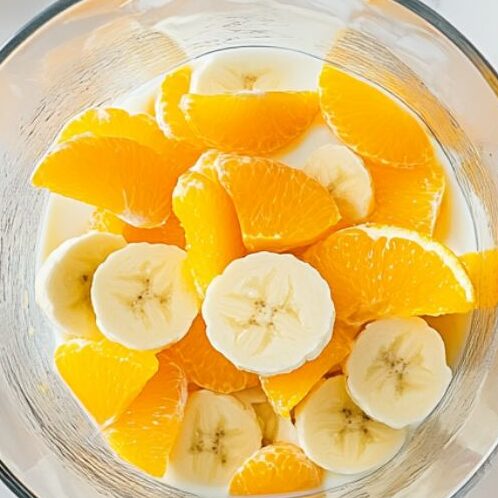 Adding orange smoothie ingredients to blender