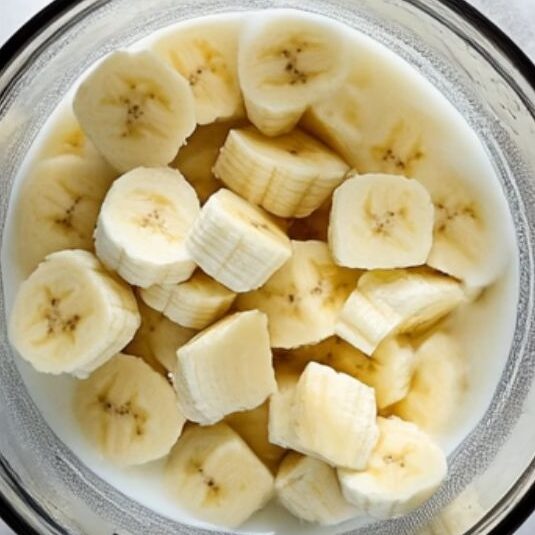 Banana, yogurt, and almond milk being added to blender