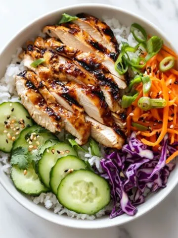 Chicken rice bowl recipe with marinated grilled chicken and colorful vegetables on jasmine rice