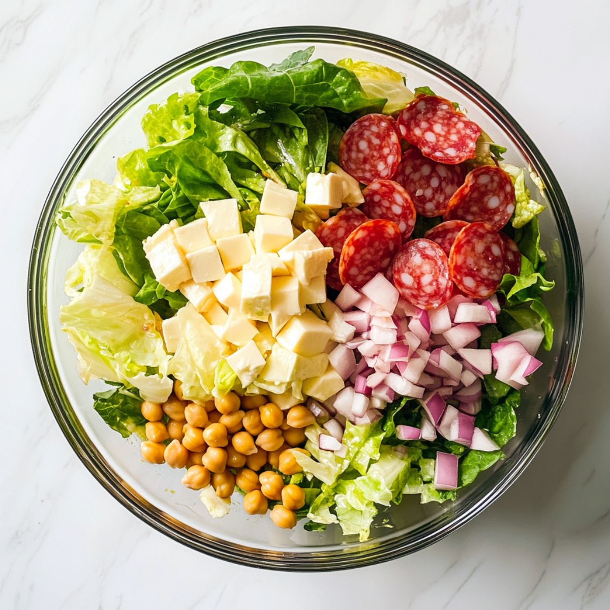 Top-down view of La Scala chopped salad recipe served in a glass bowl on a white marble counter