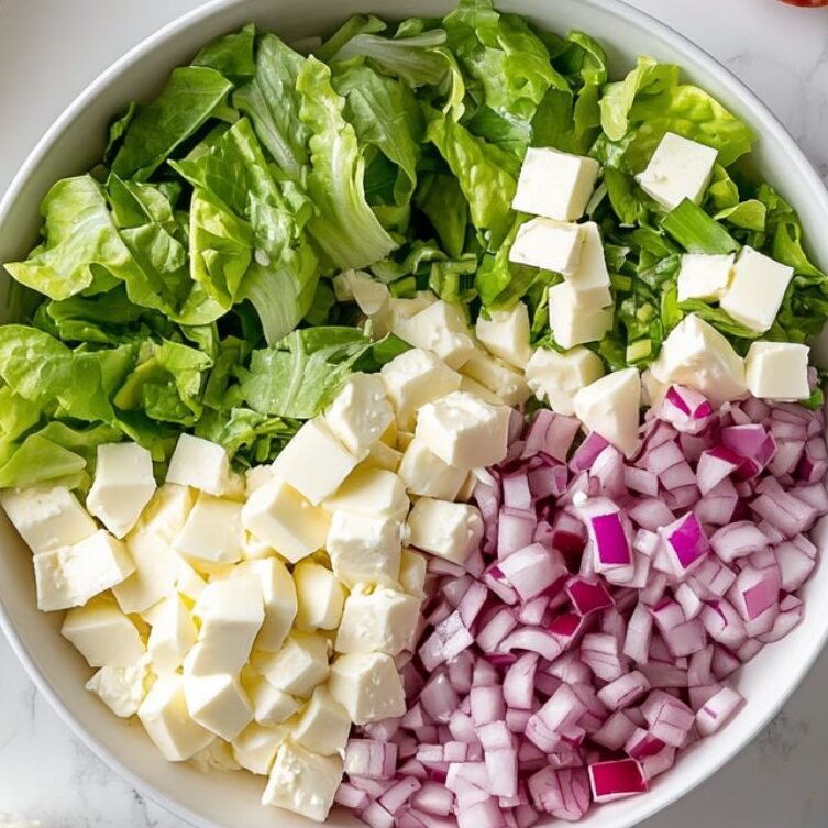 Top-down view of chopped La Scala salad ingredients prepared on a white marble kitchen counter