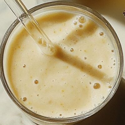 Banana smoothie served in a glass with toppings