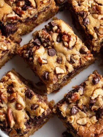 Freshly baked brown butter blondies recipe in a parchment-lined pan on a white kitchen counter
