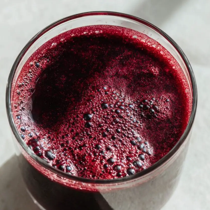 Glass of beetroot juice with lemon wedge on the side