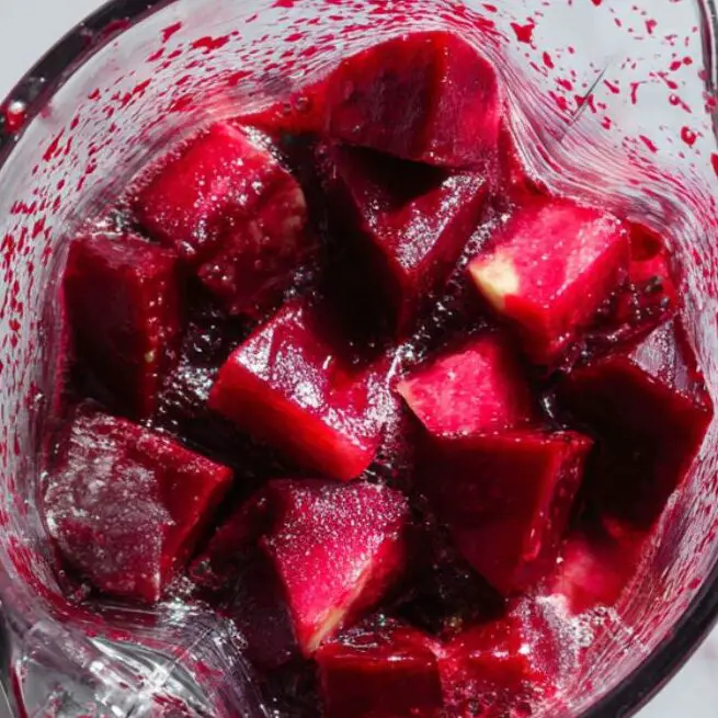 Beetroot juice being blended in a glass blender with ingredients visible