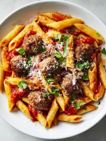 Overhead view of a hearty bowl of penne with meatballs recipe in marinara sauce