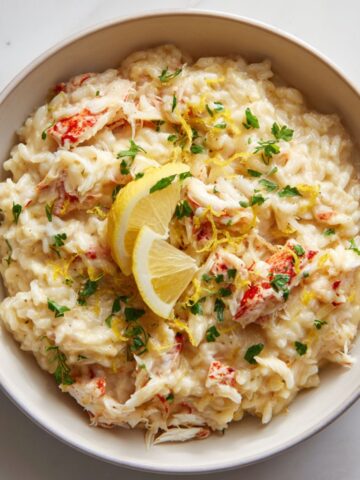 Creamy crab risotto recipe served in a white bowl with lemon zest
