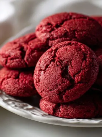 Freshly baked red velvet cookies recipe cooling on a white counter
