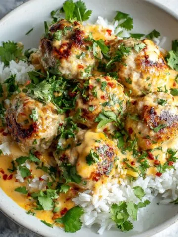 Thai chicken meatballs recipe served over jasmine rice with coconut sauce drizzle
