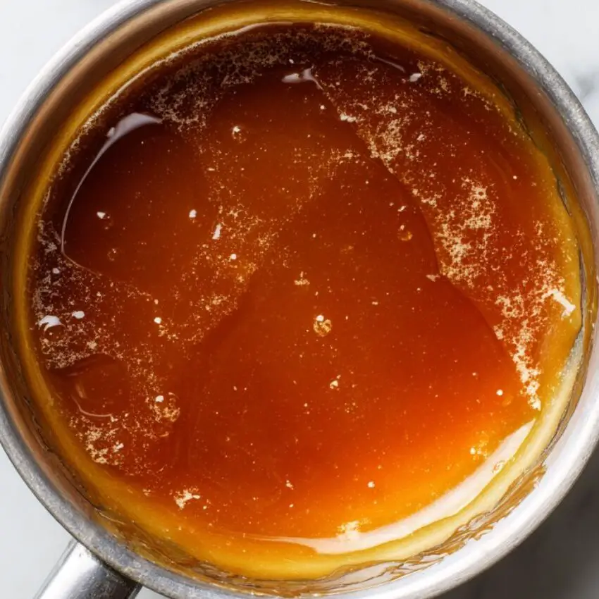 Freshly made caramel sauce cooling in a small saucepan