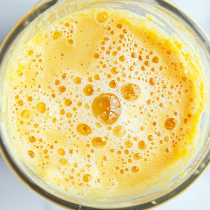 Pineapple smoothie being blended to creamy texture