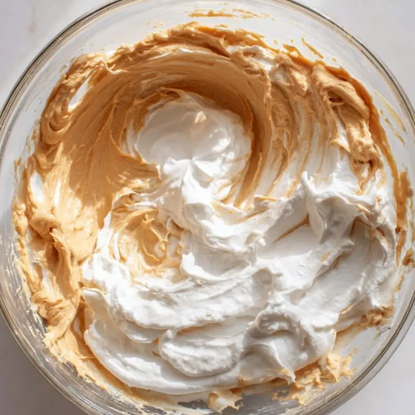 Cream cheese peanut butter filling being mixed in a glass bowl