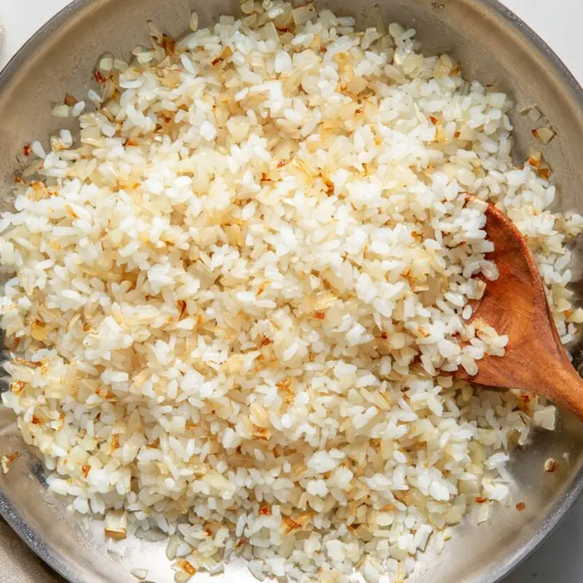 Toasting Arborio rice with shallots and garlic for risotto