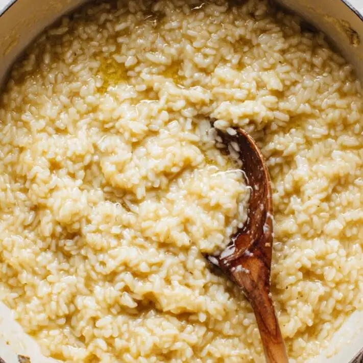 Stirring risotto while adding wine and stock