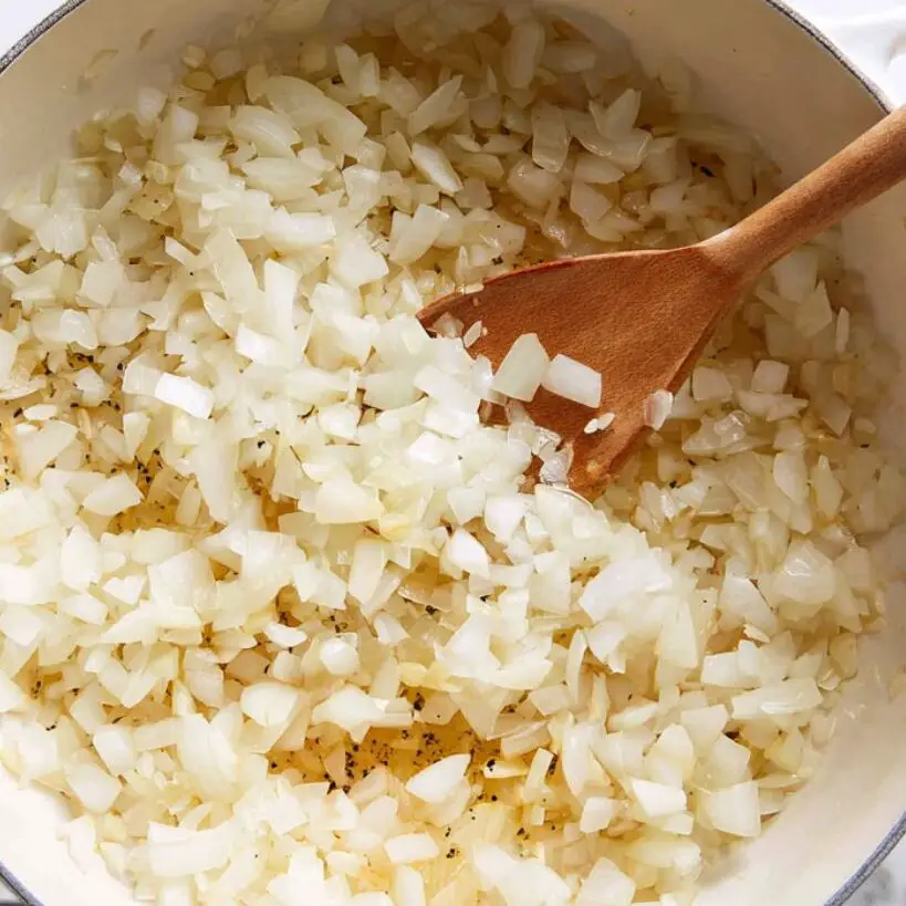 Onions, garlic, and rice cooking together in a pot