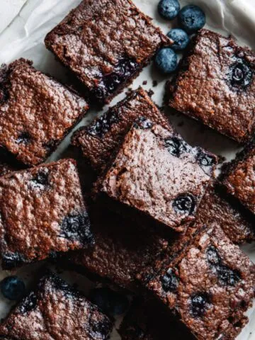 Homemade blueberry brownies recipe cut into squares on parchment paper