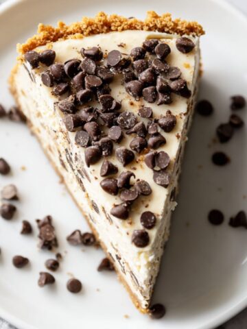 Chocolate chip cheesecake recipe slice with mini chips on white plate