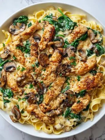 Creamy chicken tagliatelle recipe served on a white plate, overhead view with a homemade rustic feel