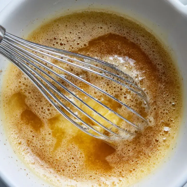 Mixing melted butter and sugar in a bowl for blueberry brownies

