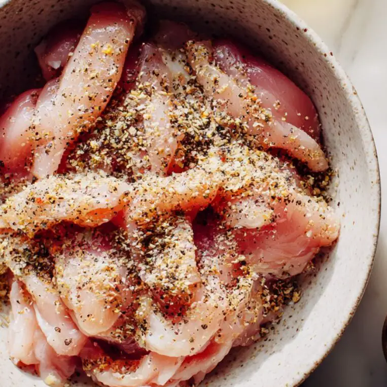 Raw chicken strips and pasta ingredients arranged before cooking