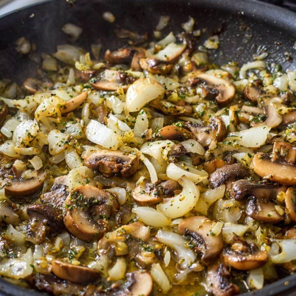 Sautéed onions, mushrooms, and garlic in a skillet forming the sauce base