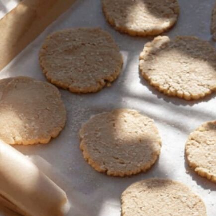 Baking setup with parchment-lined trays and cookie press ready to use.

