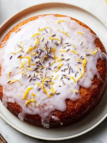 A full lavender lemon cake RECIPE with glaze on a white kitchen counter