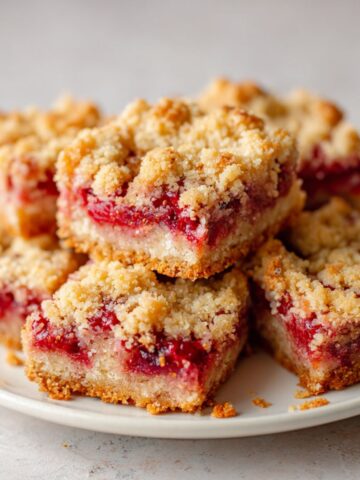 Freshly baked homemade strawberry crumb bars recipe cut into squares on a white kitchen counter