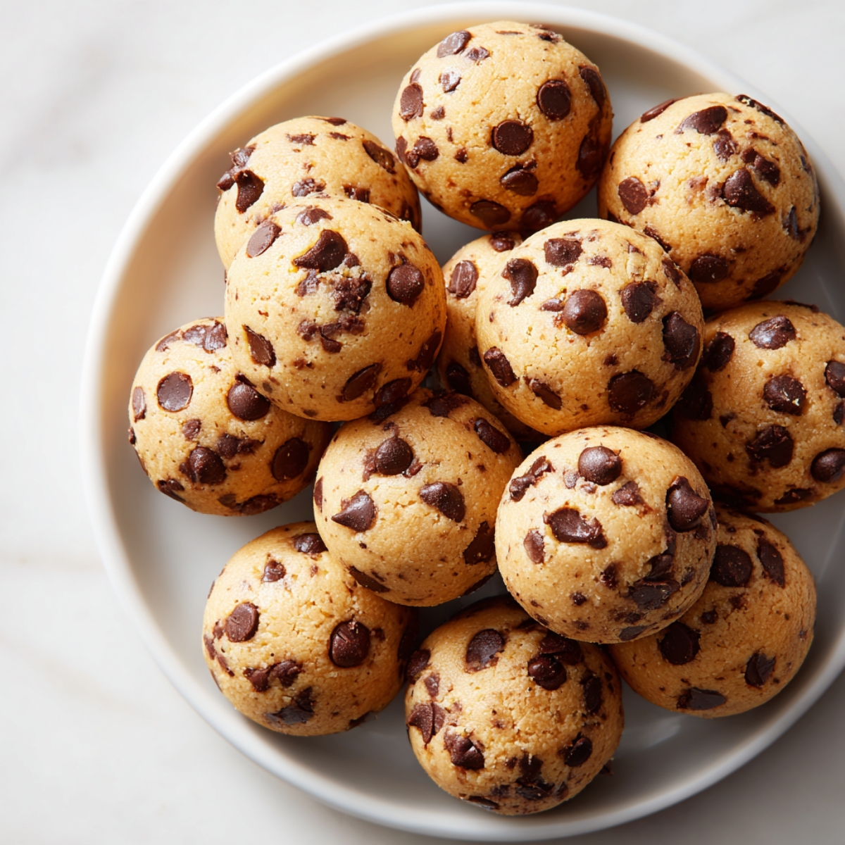 Close-up of homemade cookie dough bites recipe on a white kitchen counter

