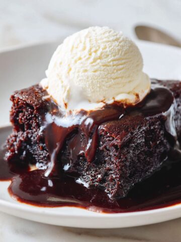 Slice of hot fudge pudding cake recipe with sauce and ice cream on a plate