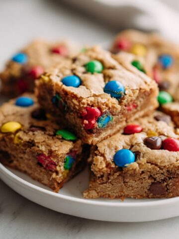 Freshly baked Mm Cookie Bars Recipe cut into squares on a baking tray