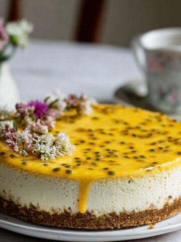 Whole passionfruit cheesecake recipe with golden topping on a white kitchen counter