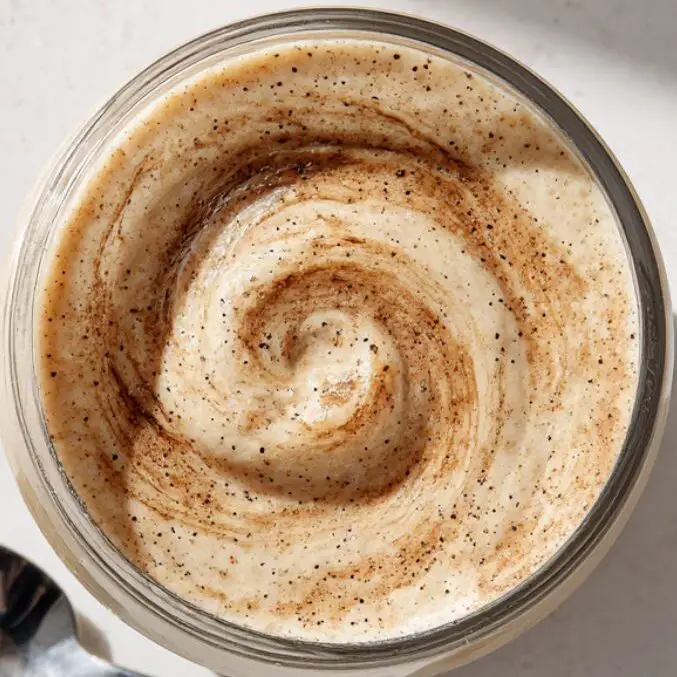 Finished cinnamon roll smoothie served in a clear glass