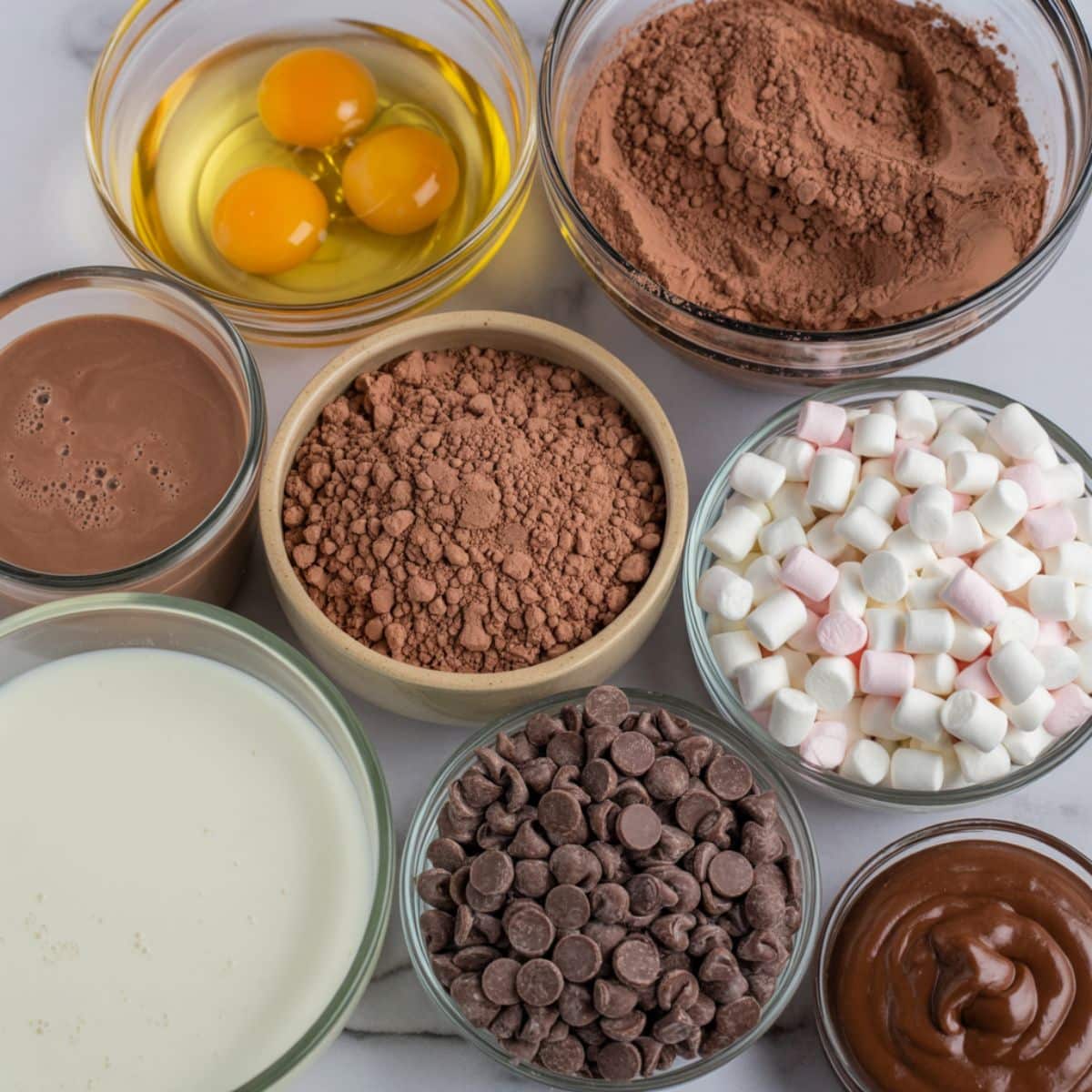 Ingredients for hot cocoa poke cake recipe laid out on a white kitchen counter
