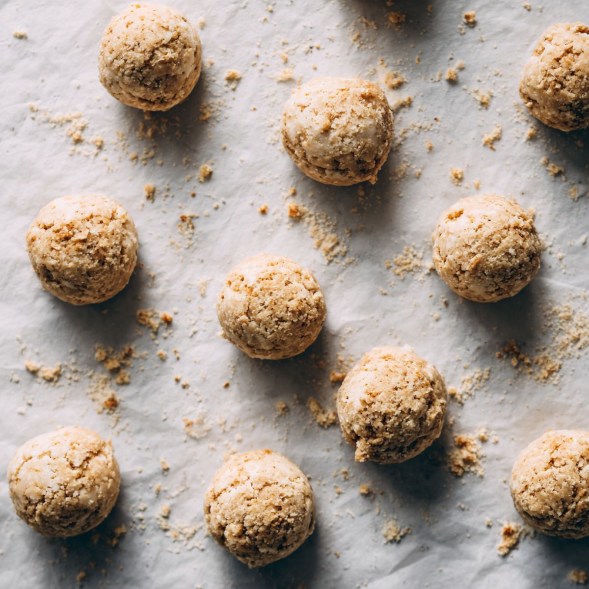 Rolled Swedish cookie dough balls arranged on a parchment-lined tray
