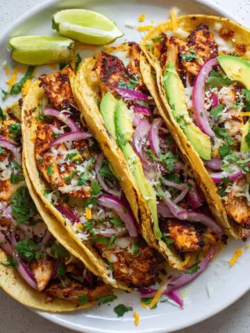 Freshly made spicy chicken tacos recipe on white kitchen counter