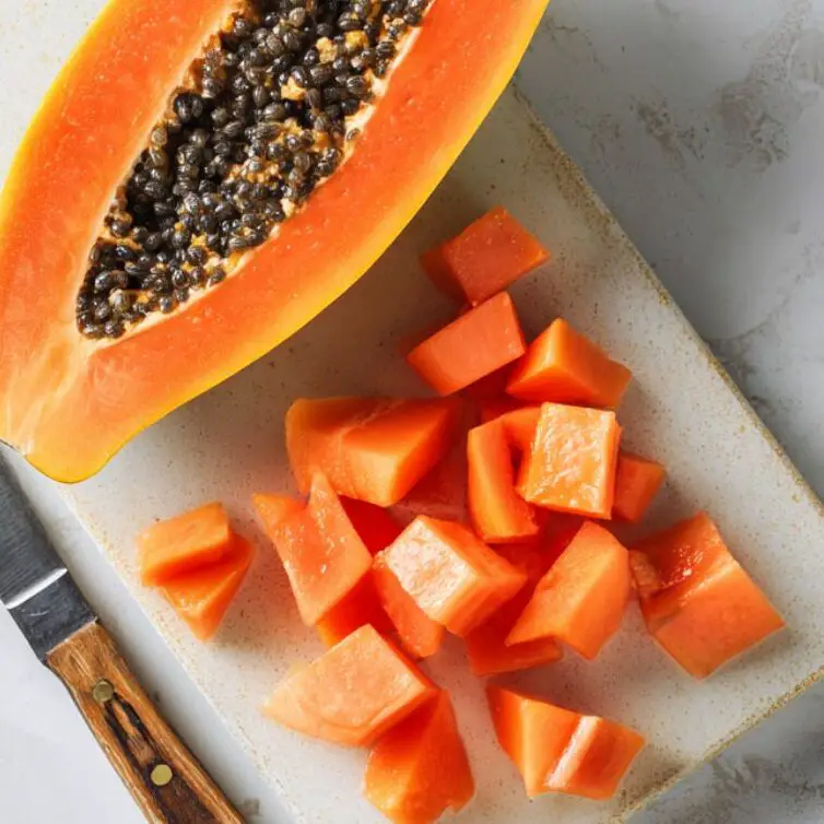 Cut papaya and chunks on a cutting board