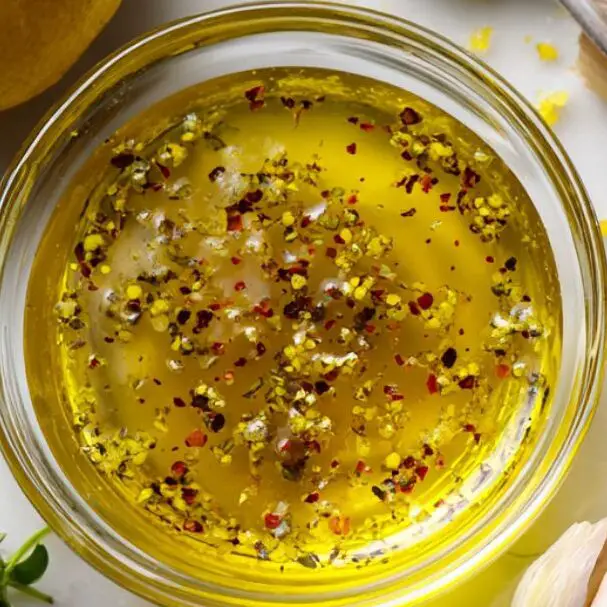 Lemon vinaigrette ingredients and dressing in a small bowl