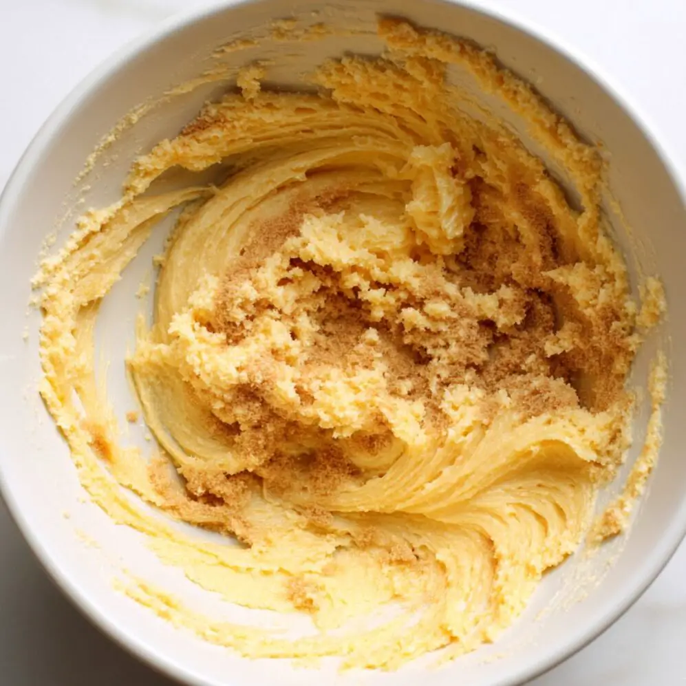 Overhead image of a mixing bowl with fluffy creamed butter and brown sugar for date cake batter.


