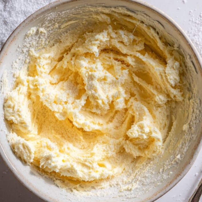 Creamed butter and sugars for cookie dough bites in a mixing bowl

