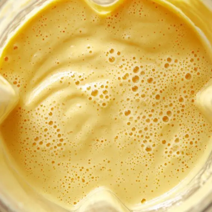 Blended passionfruit smoothie in blender with thick texture