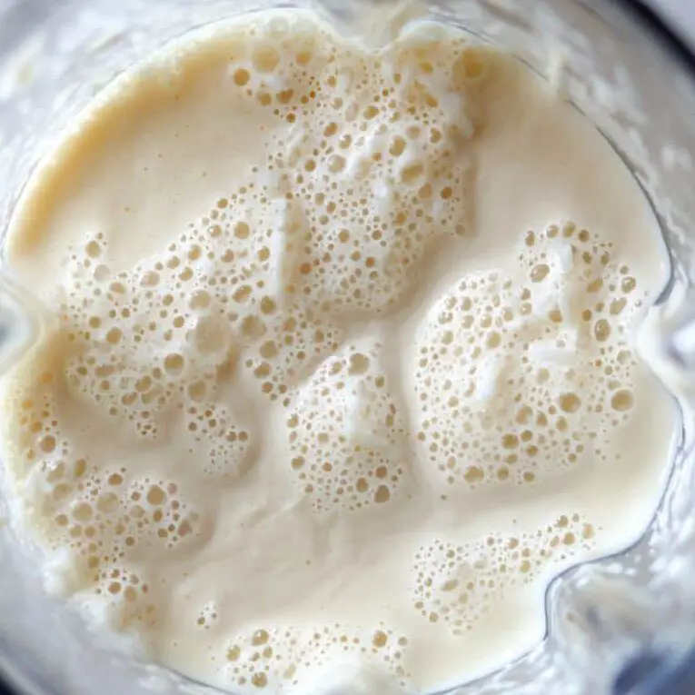 Smoothie in blender after final blend, thick and creamy texture visible