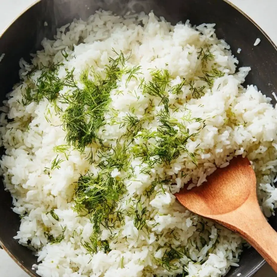 Stirring fresh dill into cooked lemon rice.