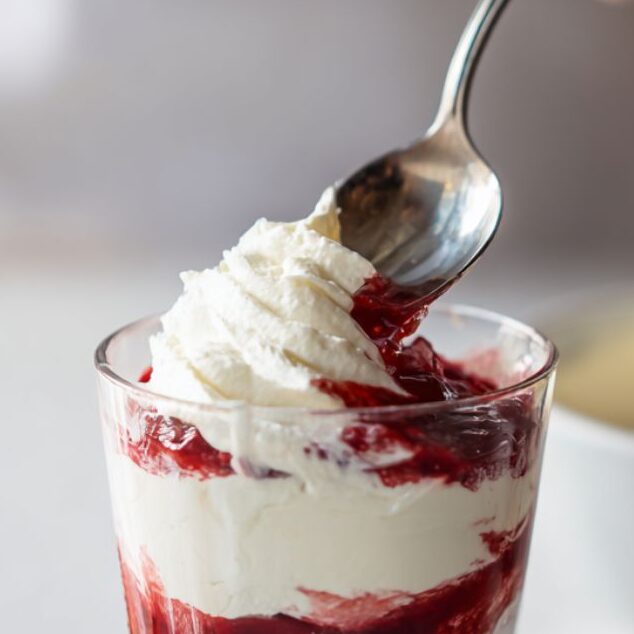 Layering red velvet pudding and cream cheese in a dessert glass
