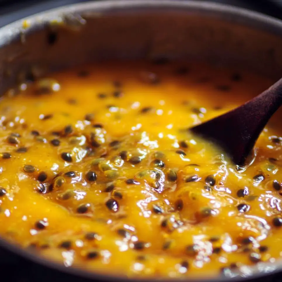 Passionfruit topping bubbling and thickening in a saucepan

